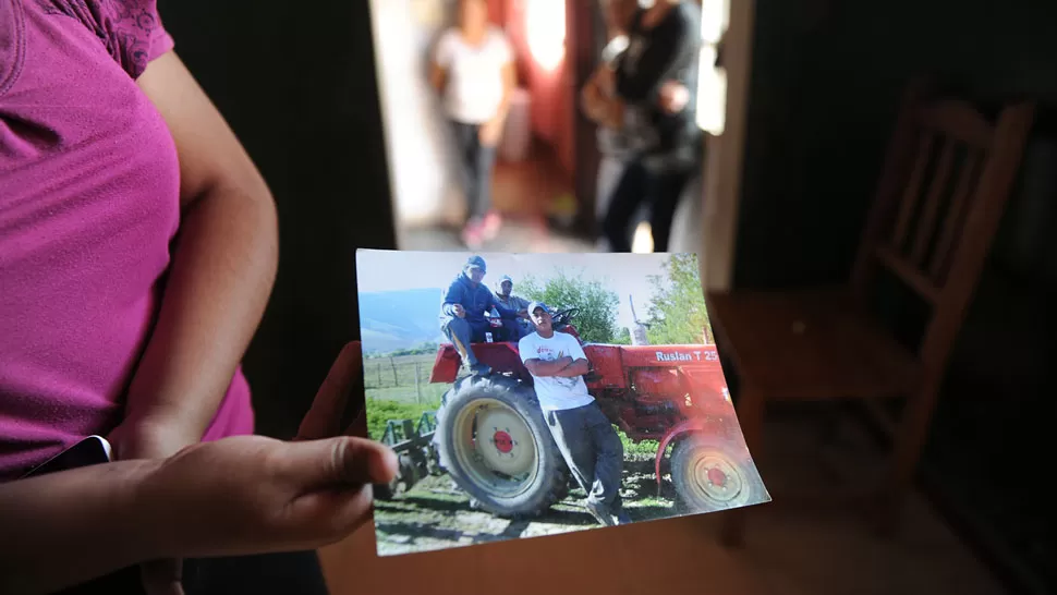 LAS VÍCTIMAS. Una allegada a la familia Moreno muestra una foto de los hombres asesinados. LA GACETA / FRANCO VERA