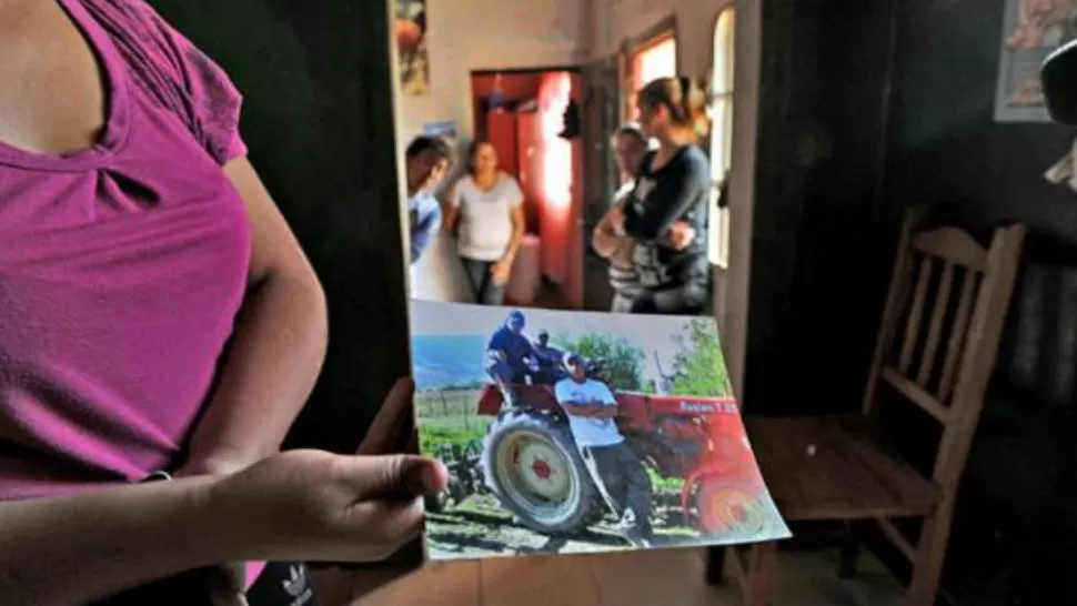 LAS VÍCTIMAS. Una allegada a la familia Moreno muestra una foto de los hombres asesinados. LA GACETA / FRANCO VERA