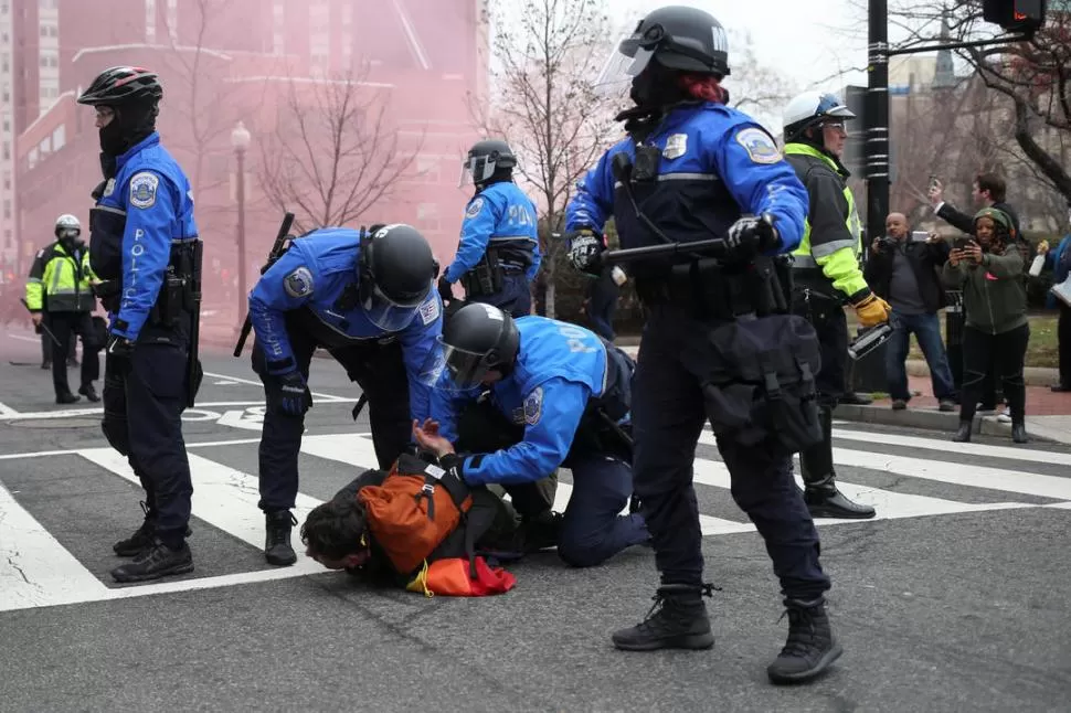 DISTURBIOS EN LA VÍA PÚBLICA. Efectivos de la policía estadounidense reducen a un manifestante en Washington. 