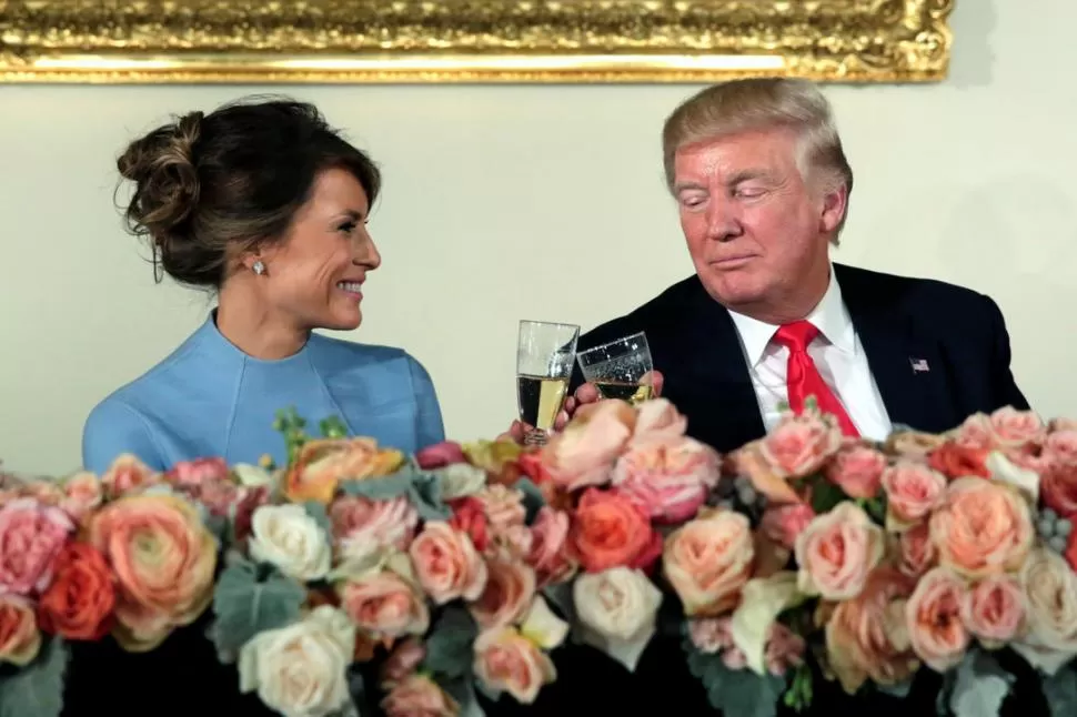 BRINDIS TRAS LAS FLORES. Trump, ya como jefe de Estado, y su esposa Melania chocan sus copas. 