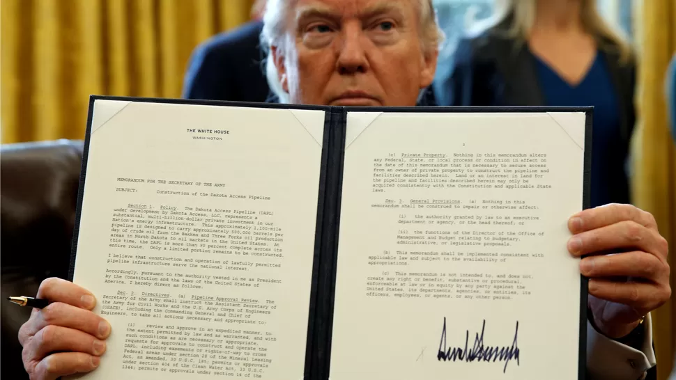 POR DECRETO. Trump exhibe su firma en la autorización para la construcción de un gasoducto en un área protegida. REUTERS