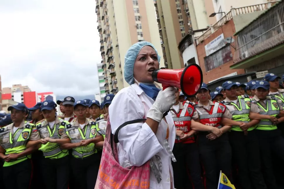 PIDE MEJORAS. Una mujer grita lemas delante de la policía antidisturbios durante la manifestación de ayer. Reuters