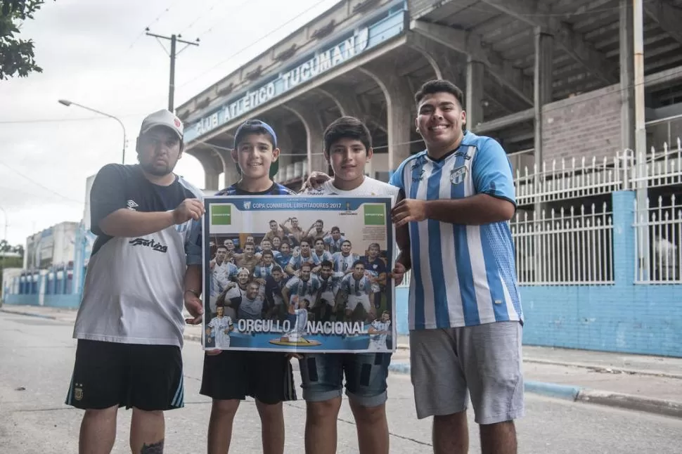 ILUSIONADOS. Con el Monumental de fondo, cuatro fanáticos de Atlético sostienen el póster “decano” de LA GACETA.  la gaceta / foto de adrián lugones