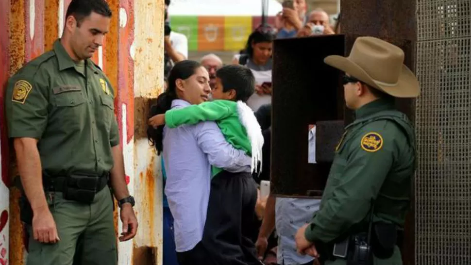 Una madre cruza con su hijo la frontera entre EEUU y México por California. REUTERS
