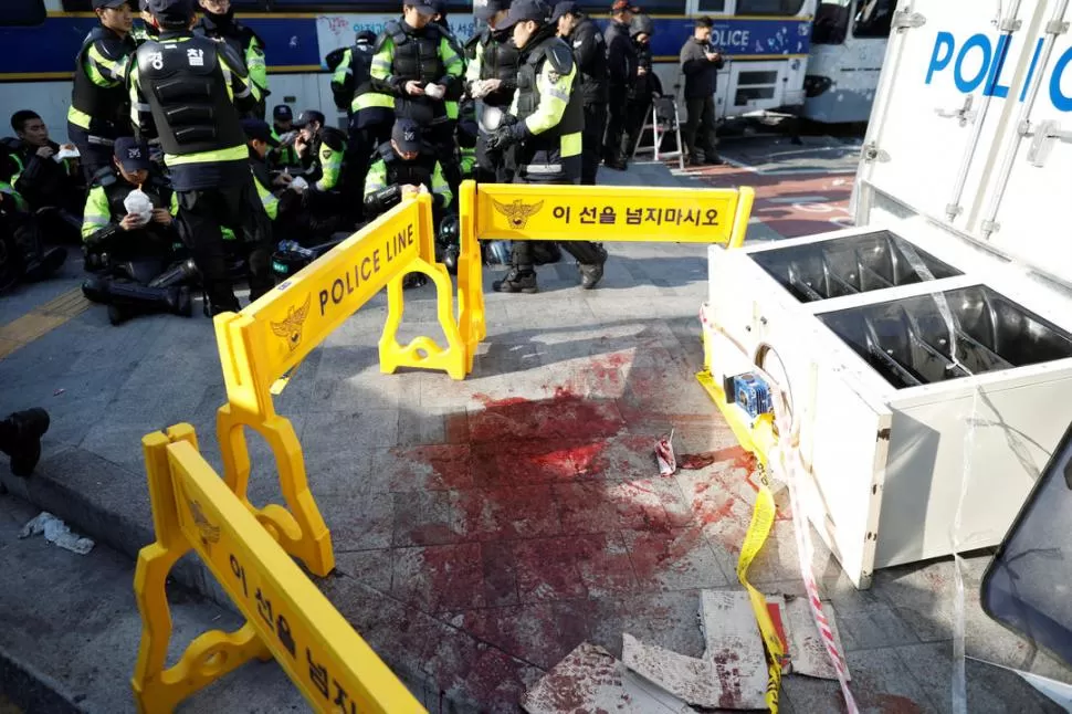 PARA LA INVESTIGACIÓN. La policía de Seúl acordonó el lugar donde cayó muerto uno de los manifestantes. fotos reuters