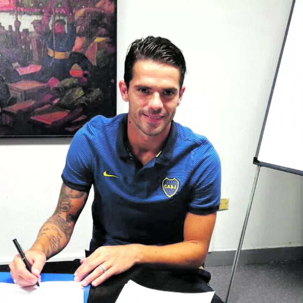 FINAL FELIZ. Fernando Gago, sonriente, estampa su firma en el nuevo contrato. TWITTER @BocaJrsOficial