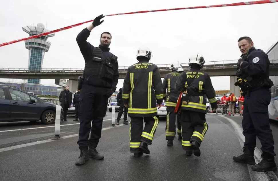 INCIDENTE. Policías bloquean uno de los accesos a la aeroestación parisina. reuters