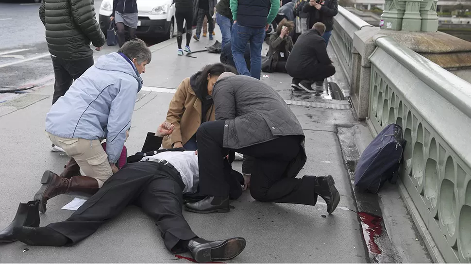 REACCIÓN. La gente asiste a una víctima tras el incidente. FOTO DE REUTERS. 