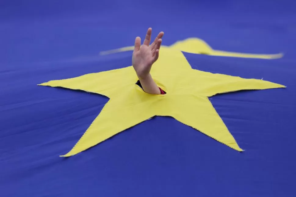 ALEGORÍA. Un niño extiende la mano pidiendo ayuda para la UE. reuters