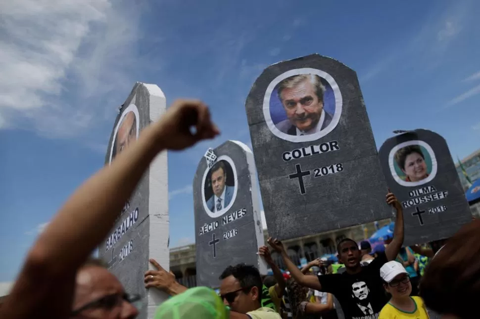 EN BRASILIA. Los manifestantes llevaron carteles simulando lápidas de un cementerio, máscaras y muñecos con los rostros de los políticos repudiados. reuters 