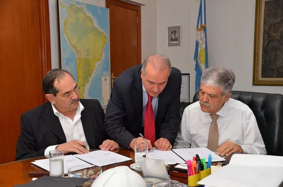 OTROS TIEMPOS. José Alperovich, José López (con la lapicera) y Julio De Vido rubricaron varios acuerdos para obras públicas destinadas a Tucumán. archivo