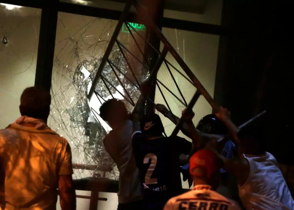 NOCHE VIOLENTA. Manifestantes rompen un ventanal del Congreso. reuters