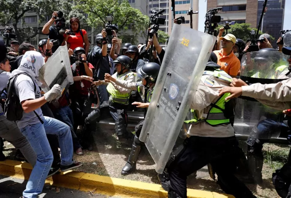 DE PELÍCULA. Los manifestantes (izquierda) chocaron con la policía ante las cámaras fotográficas y de televisión. reuters 