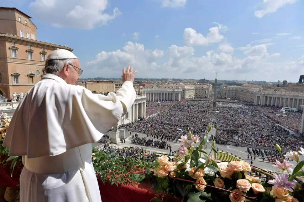 UN MENSAJE ESPIRITUAL Y POLÍTICO. Desde el balcón de San Pedro, rodeado de flores holandesas, el Papa abogó por la paz. La multitud, atenta. reuters