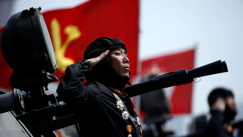 MILITAR COREANO. Un soldado condecorado realiza un saludo militar junto a su arma. REUTERS