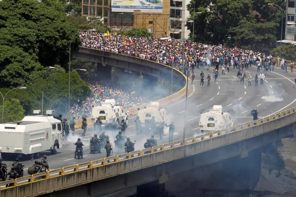 VIOLENCIA. Los manifestantes chocaron ayer con la policía antidisturbios, en una autopista de acceso a Caracas, durante la llamada “madre de todas las marchas” contra la administración del presidente de Venezuela, Nicolás Maduro. reuters