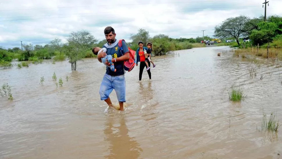 TREMENDA POSTAL. Personas afectadas por las inundaciones intentan escapar del agua. LA GACETA / FRANCO VERA