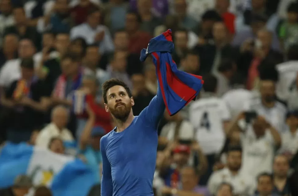 OFRENDA. Messi enseña su camiseta a los hinchas de Barcelona luego del gol con el que definió el clásico en Madrid. REUTERS