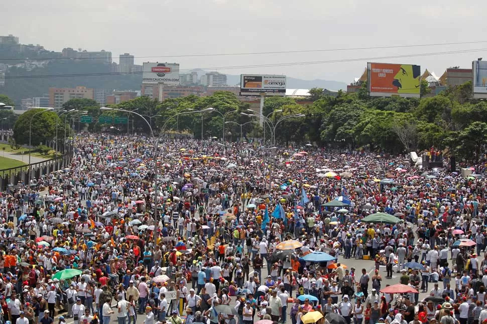 BAJO EL SOL Y CON SOMBRILLAS. Los opositores al régimen de Nicolás Maduro se vistieron de blanco. Reuters