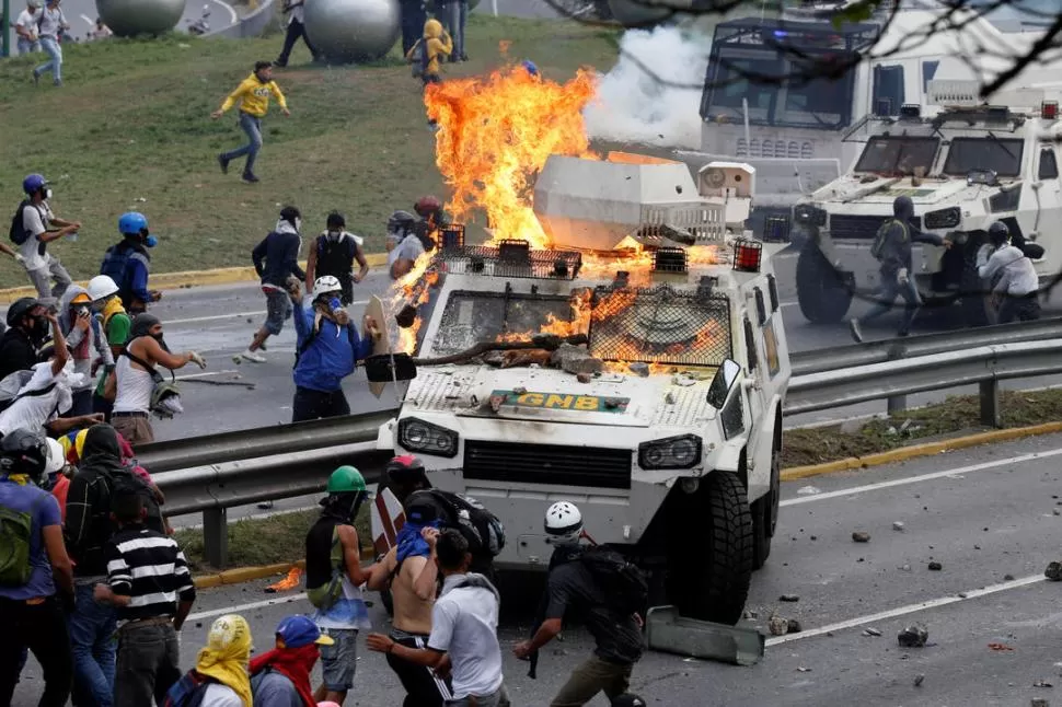 DESTRUCCIÓN. Una tanqueta de la Guardia Nacional Bolivariana arde bajo el ataque con bombas molotov de grupos opositores al Gobierno. reuters 