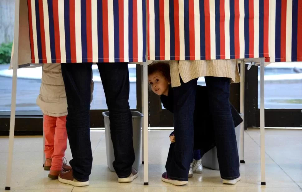 EN WASHINGTON. Un niño mira desde una cabina de votación. Los franceses residentes en el exterior comenzaron a votar desde ayer. reuters