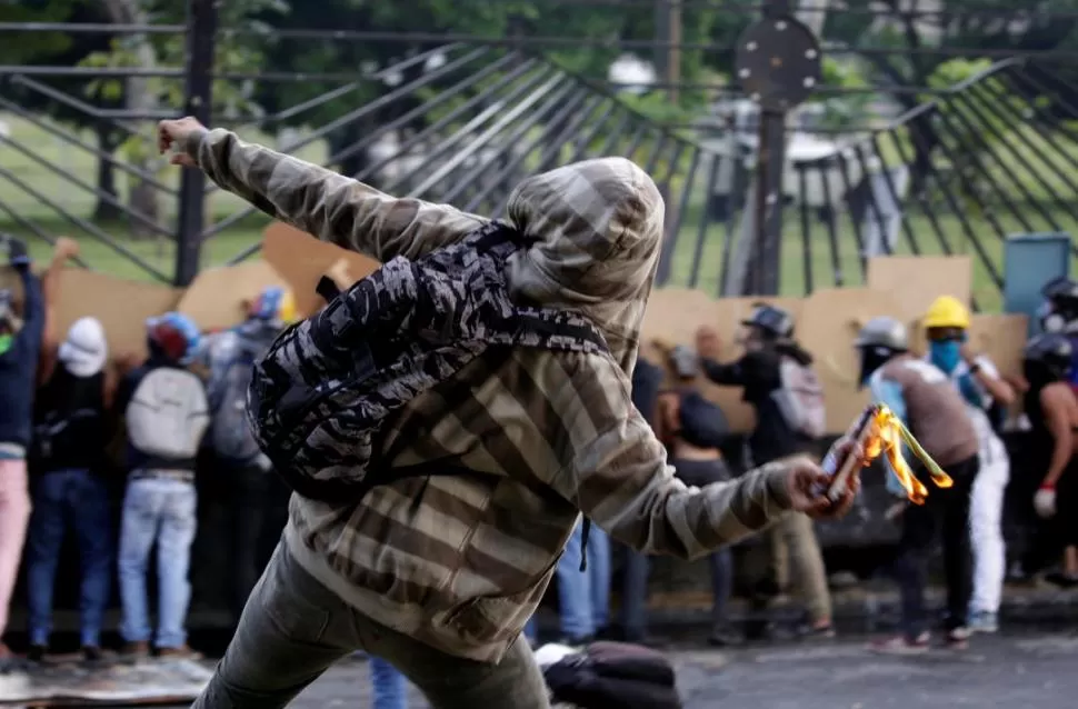 VIOLENCIA. Un manifestante responde a la represión de  las fuerzas de seguridad arrojando una bomba molotov. Reuters