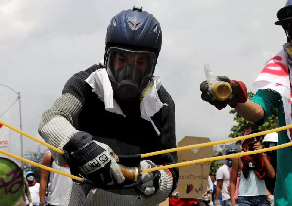 UNA BOMBA. Un manifestante lanza una “popotovs” contra los policías. REUTERS