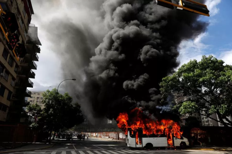 EN CARACAS. Un ómnibus de pasajeros se incendia por la acción de opositores, durante las protestas contra el régimen de Nicolás Maduro. reuters