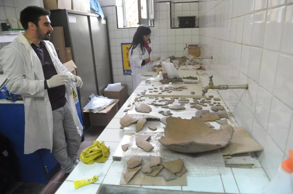 ROMPECABEZAS. Los arqueólogos Guillermo Ortiz y Soledad Ibañez reconstruyen en el laboratorio los fragmentos de los restos hallados en Tafí. LA GACETA / FOTO DE FRANCO VERA.-