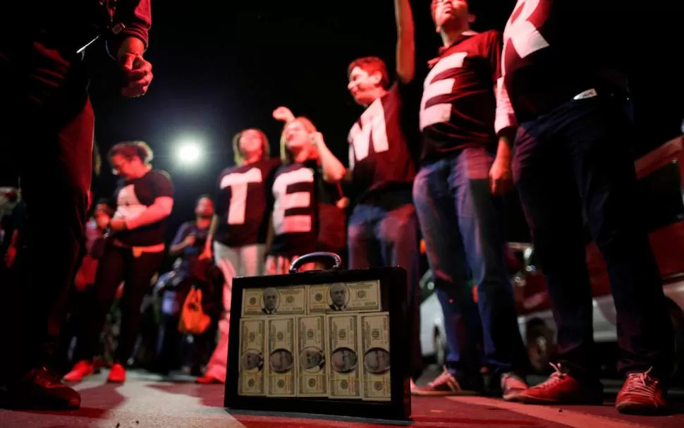 CORRUPCIÓN. Manifestantes anti Temer llevaron una valija con una imagen de dinero pegada en sus costados. Reuters