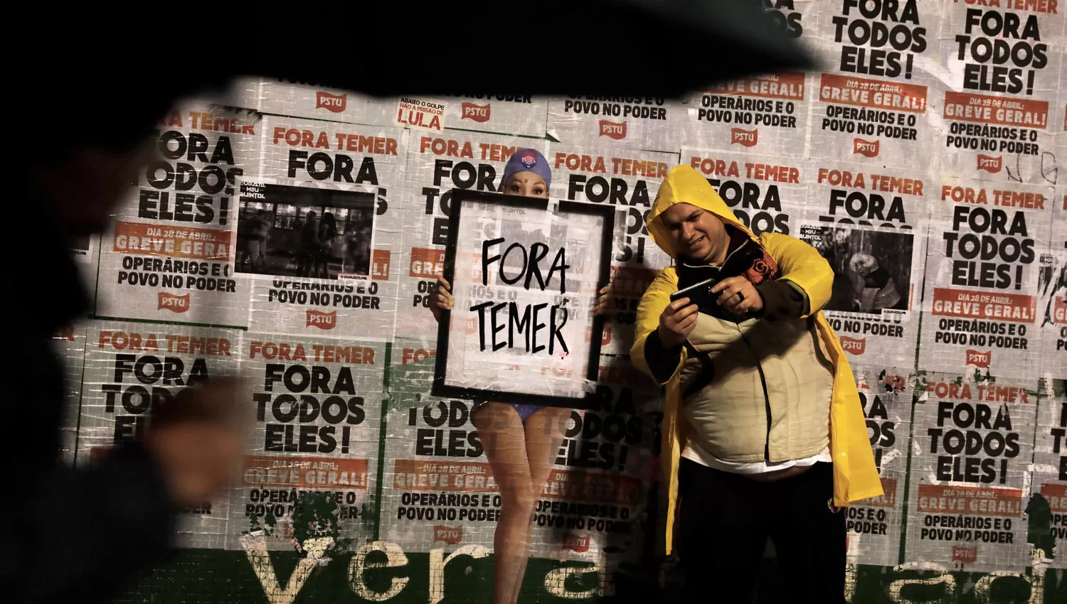 FUERA TEMER. Un hombre se toma una foto junto a un graffiti que pide la renuncia del presidente. REUTERS