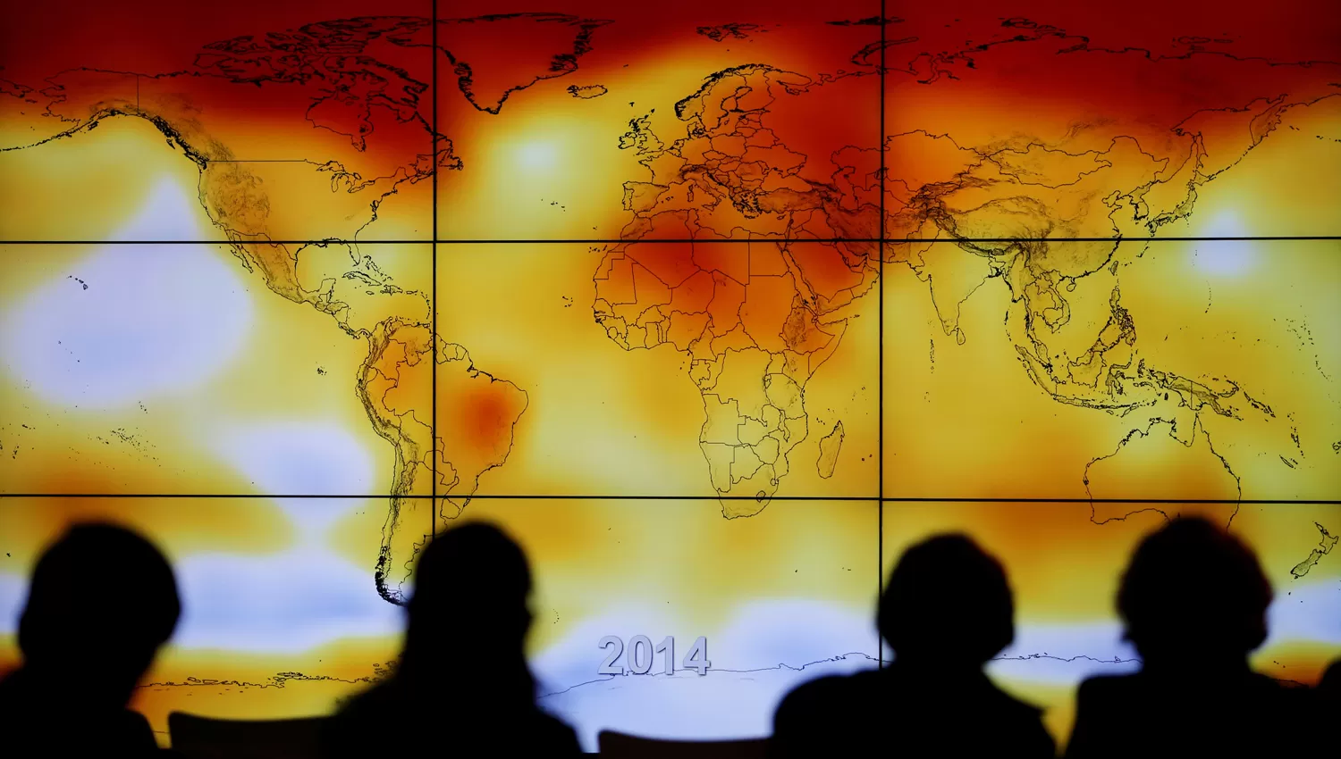 EL PACTO. Participantes de la conferencia sobre el cambio climático 2015 miran un mapa que ilustra el calentamiento global. REUTERS