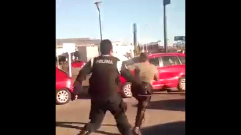 EL ATAQUE. El policía la persigue en la calle, con el látigo en la mano.  captura de video