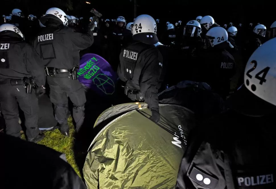 EN ACCIÓN. La Policía de Hamburgo levanta las tiendas de campaña de los manifestantes que se convocaron para repudiar la realización de la cumbre. Reuters