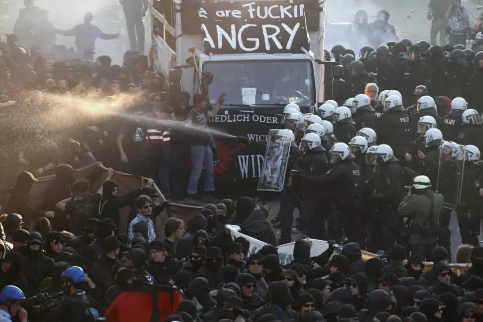 CARA A CARA. La Policía antidisturbios se enfrenta a los manifestantes que rechazan la cumbre en Hamburgo. reuters