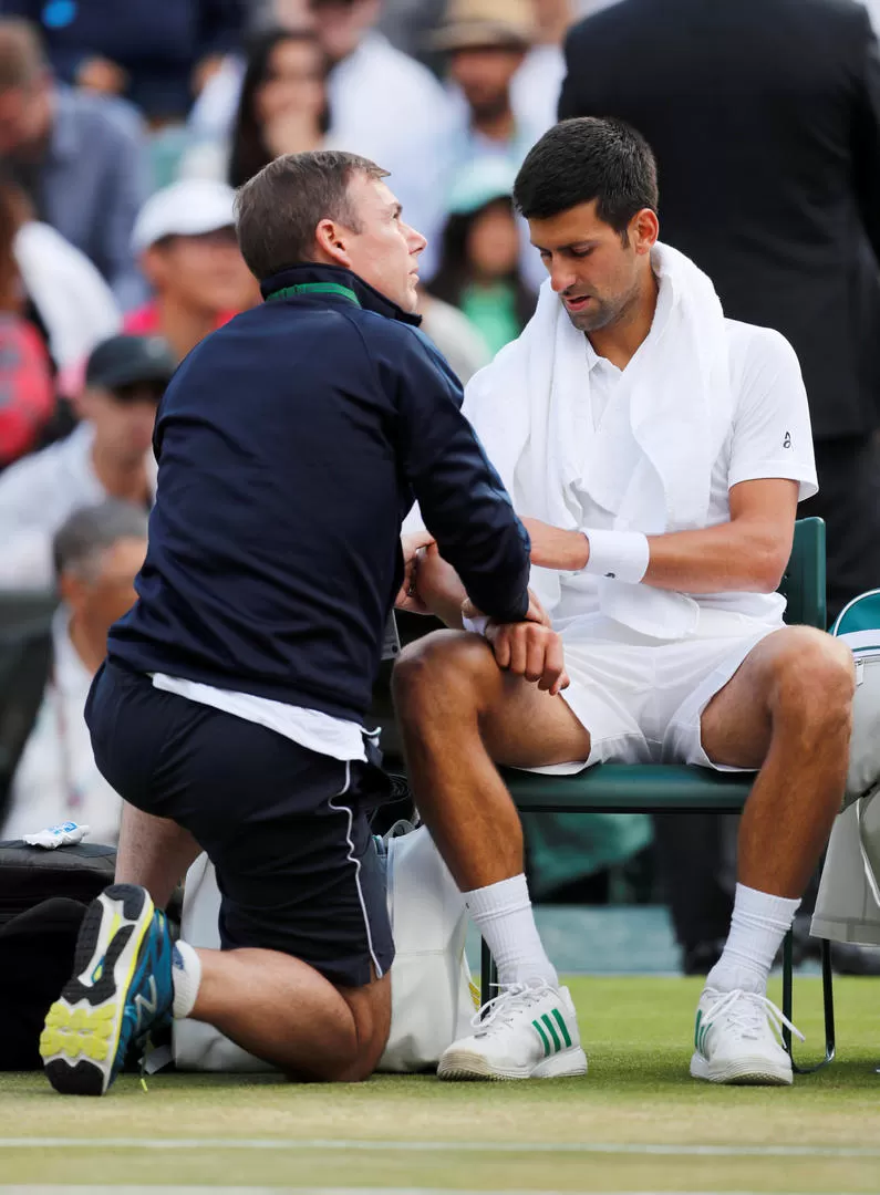 PREOCUPADO. Djokovic es asistido por el dolor que sintió en el codo derecho. Reuters