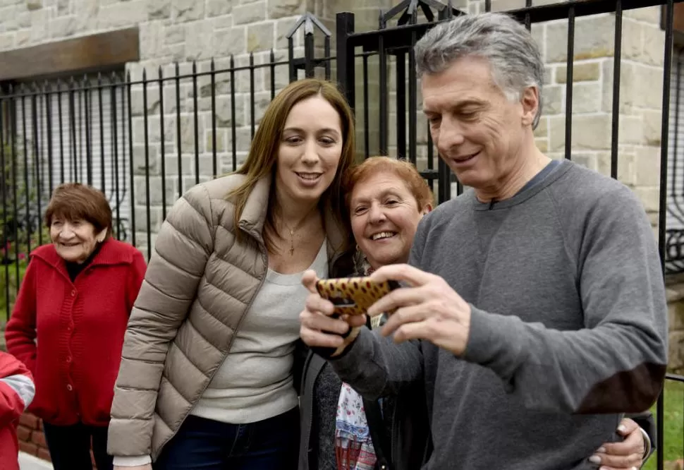 UNA “SELFIE” TODOS JUNTOS. El presidente Mauricio Macri se toma una fotografía con una vecina de Haedo y la gobernadora María Eugenia Vidal. DYN