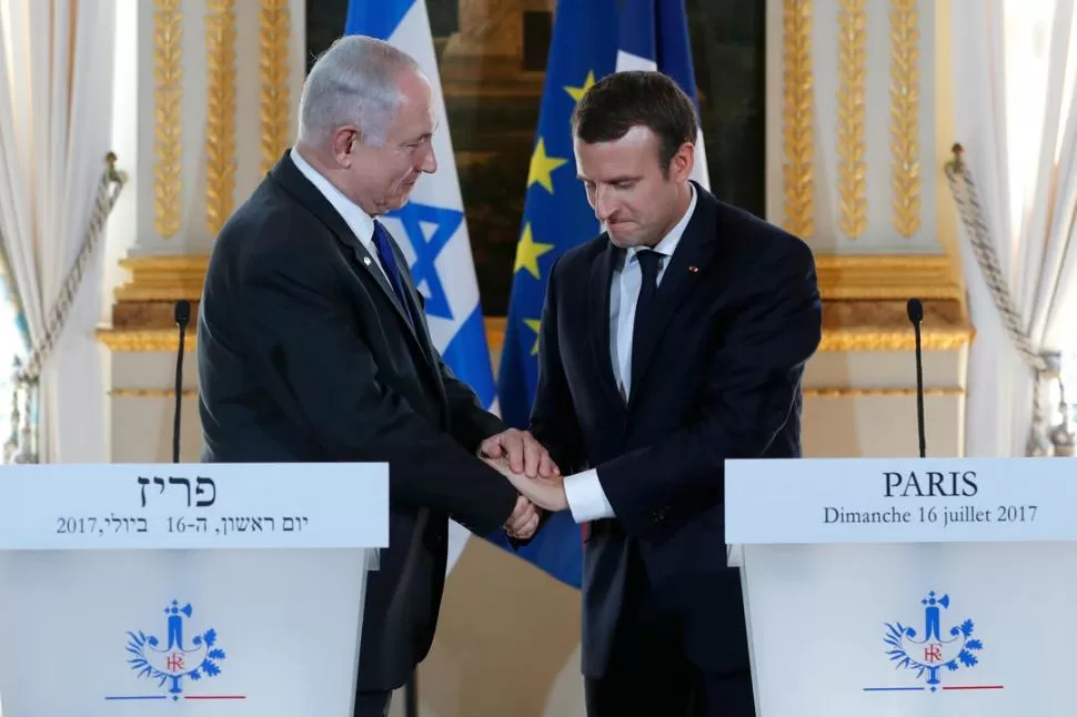 SALUDO CORDIAL. Macron y Netanyahu se estrechan las manos en París. Reuters