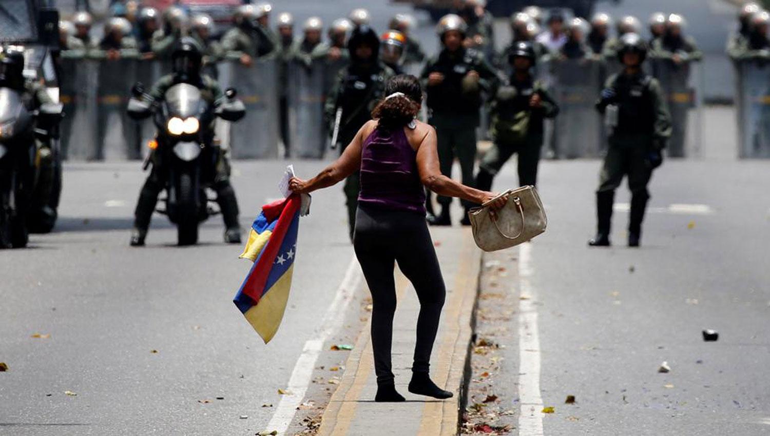 REPRESIÓN. Una mujer se enfrenta a las fuerzas de seguridad chavistas. FOTO TOMADA DE LA VANGUARDIA