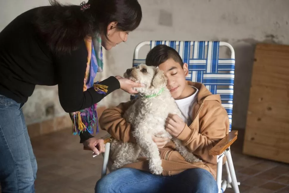 EN LA CASA. Agustín con su mamá, Luisa, y su mascota. El niño se recupera en su hogar, donde tuvo que aprender todo de nuevo. LA GACETA / FOTO DE INÉS QUINTEROS ORIO.-