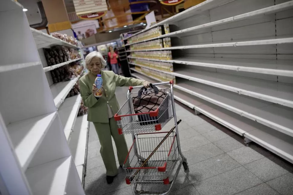 APROVISIONÁNDOSE. La gente compra productos básicos en un supermercado, casi vacío, de Caracas. Reuters