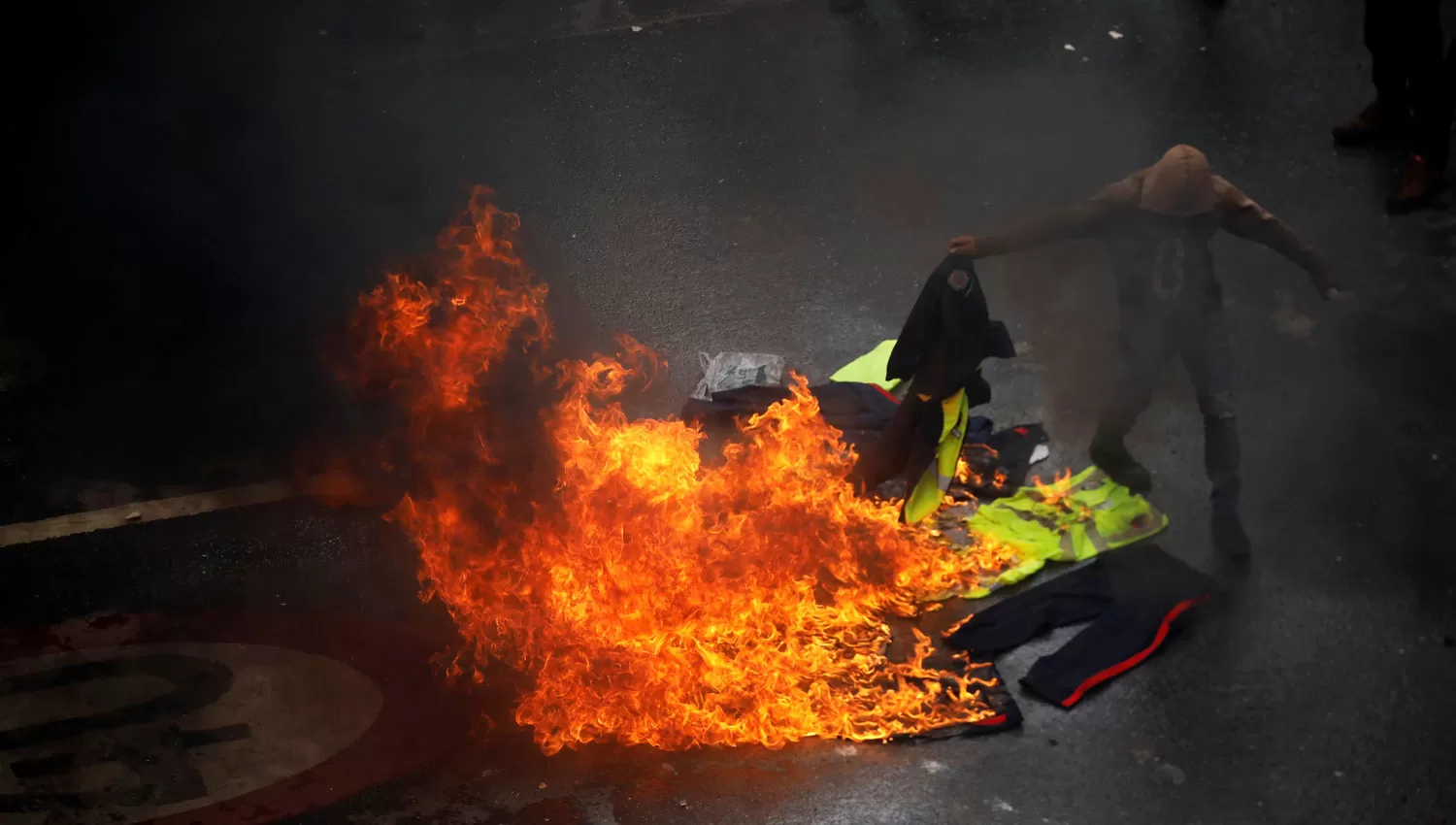 PROTESTAS. Un manifestante quema uniformes en Caracas, durante las protestas contra la Asamblea Constituyente. REUTERS