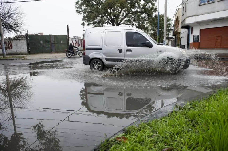 FOCO INFECCIOSO. Un automovilista avanza por Monteagudo, mientras las ruedas levantan agua contaminada. LA GACETA / FOTO DE JORGE OLMOS SGROSSO.-