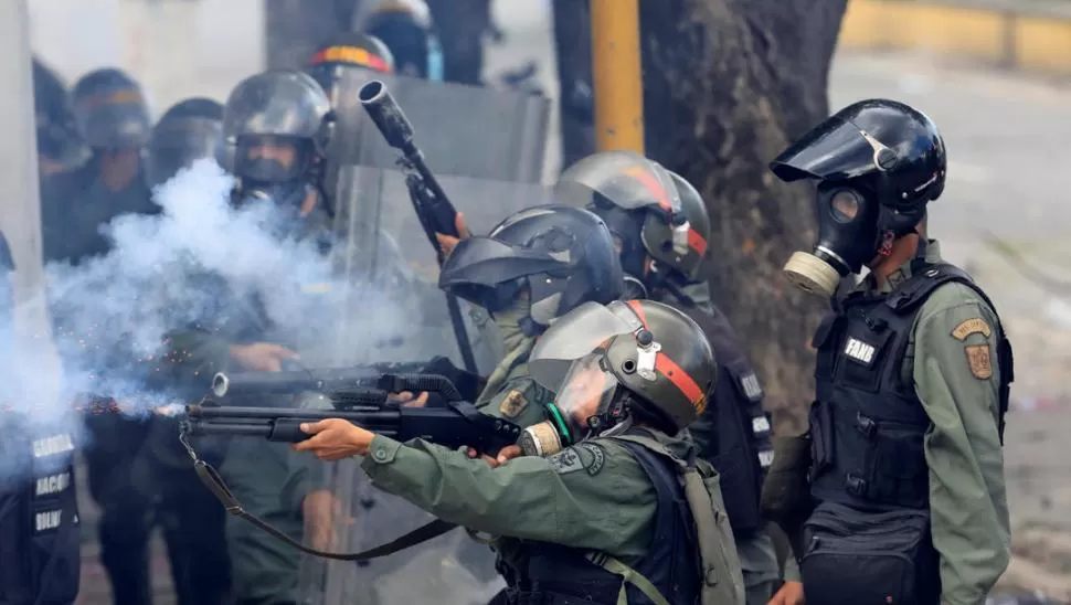 CARACAS. Integrantes de las fuerzas de seguridad antidisturbios disparan contra manifestantes que se movilizaron en contra del gobierno de Maduro. reuters 