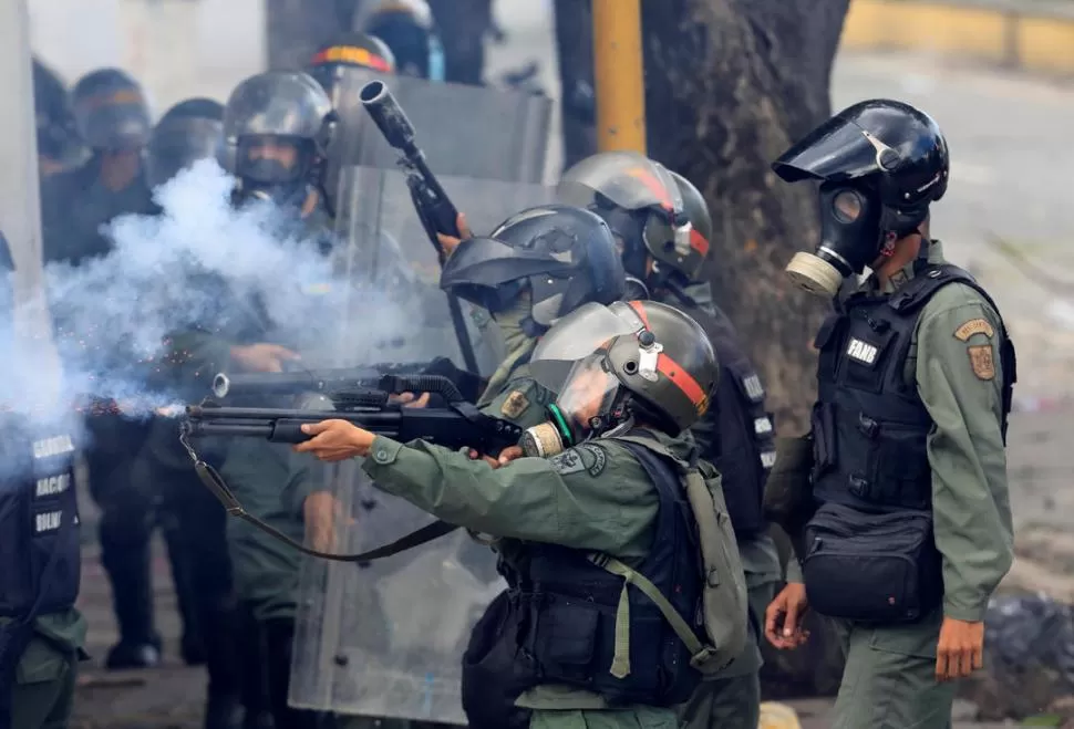 CARACAS. Integrantes de las fuerzas de seguridad antidisturbios disparan contra manifestantes que se movilizaron en contra del gobierno de Maduro. reuters 