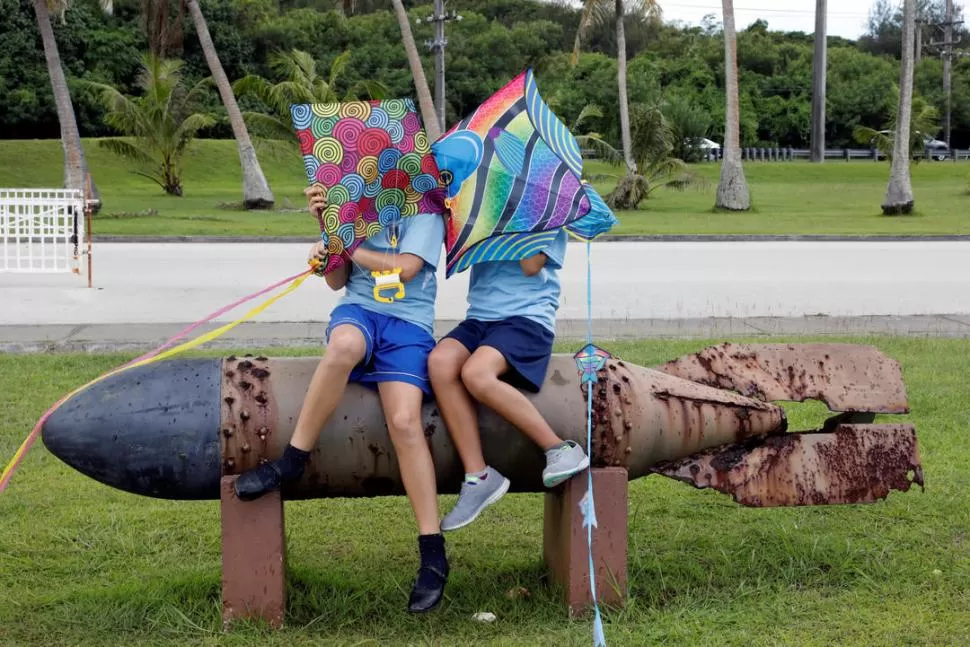 INOCENTES. Niños de la isla de Guam juegan en una plaza donde las viejas bombas de la Segunda Guerra Mundial se utilizan como bancos. credito