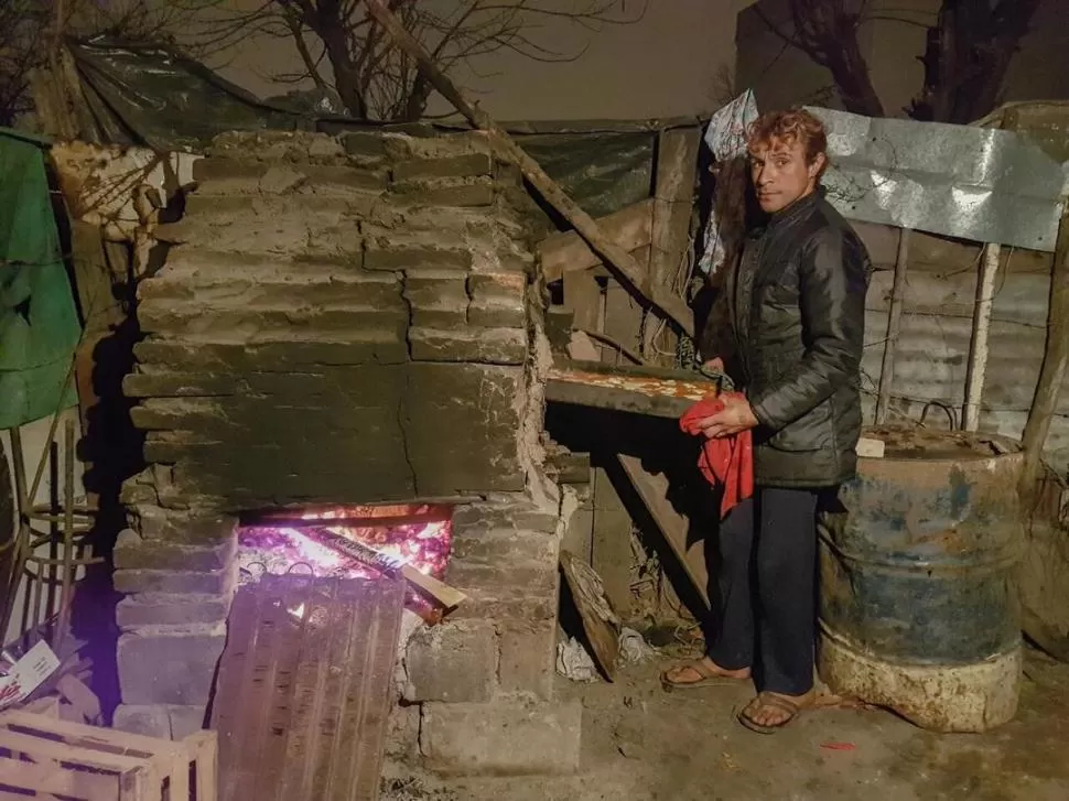 INTEMPERIE. Ponce saca una asadera del horno de barro construido en su patio, donde funciona el comedor. la gaceta / foto de Dzienczarski