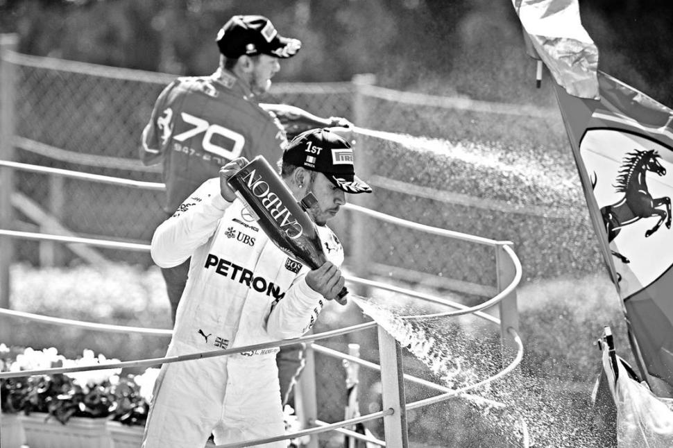 POSTAL DE MONZA. El podio, con Hamilton y Vettel tirando champaña al público, y la bandera de Ferrari en sitio protagónico. PRENSA MERCEDES
