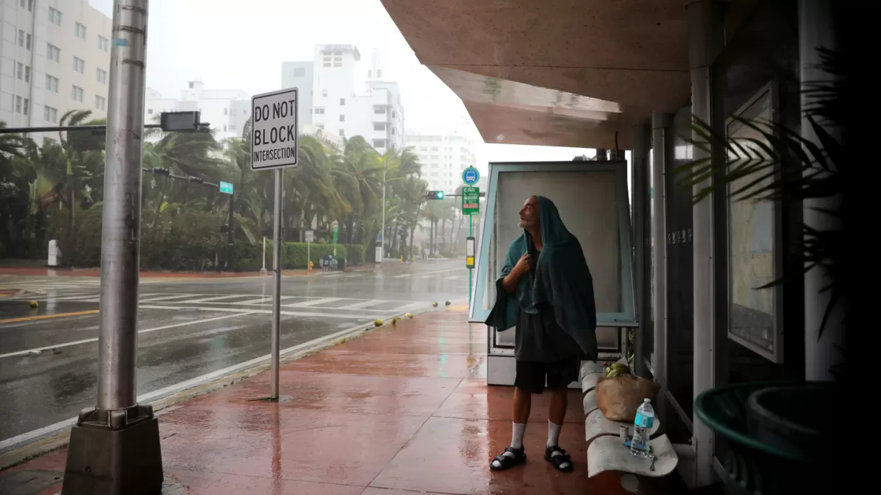 Un hombre sin hogar se resguarda en una parada de colectivos, en South Beach, Miami. REUTERS