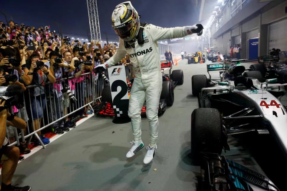 FELICIDAD. Tras bajarse del auto, Hamilton celebra su tercera victoria en fila de la temporada y la N° 60 en la categoría. reuters